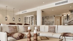 A spacious living room with a large sectional sofa, a coffee table, and decorative items. - Villa Luna Suites (Puigderrós)