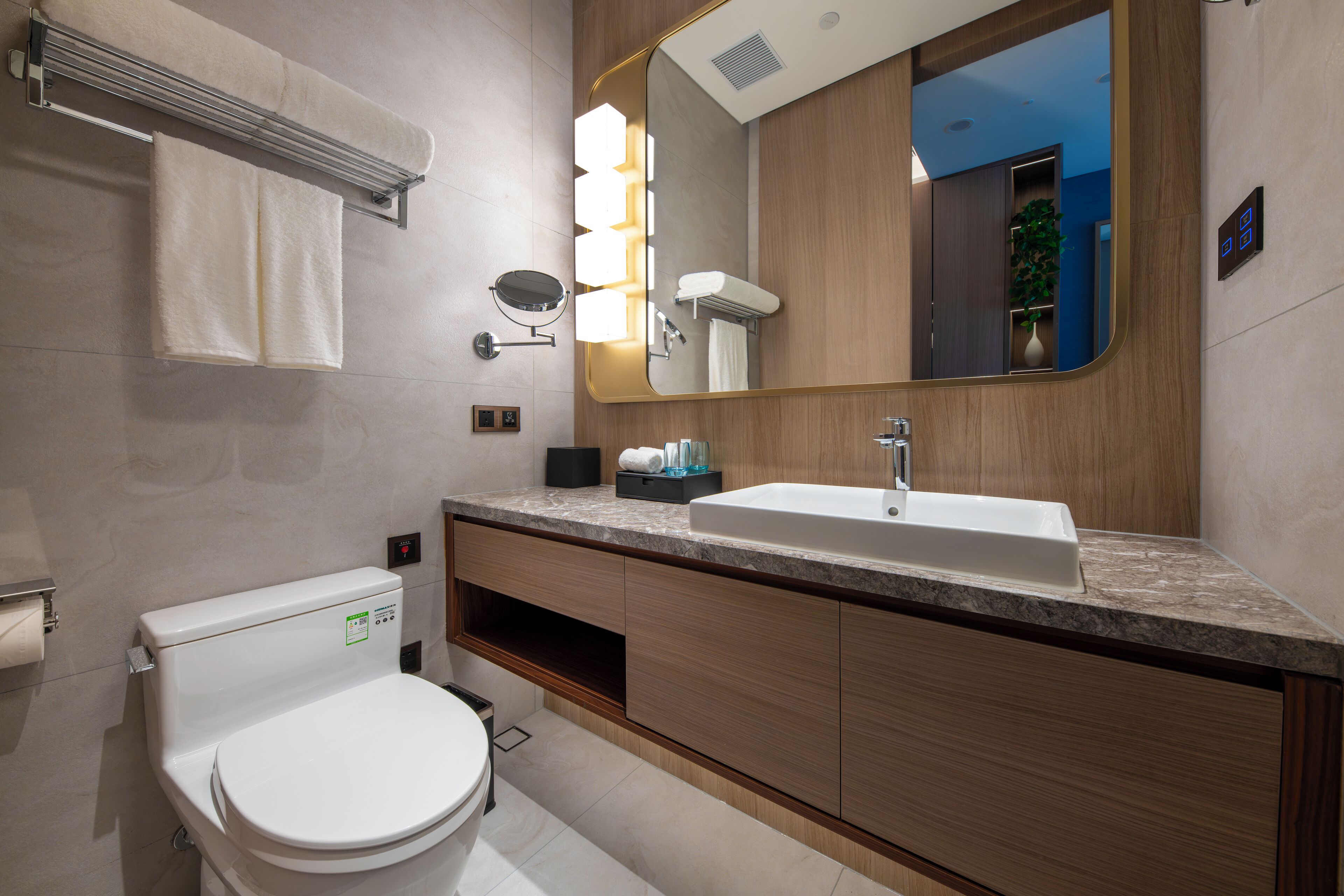 Un baño moderno con inodoro, lavamanos y espejo.