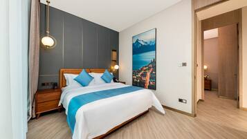 Una habitación de hotel moderna con una cama grande, cabecera de madera y un cuadro de paisaje urbano en la pared.