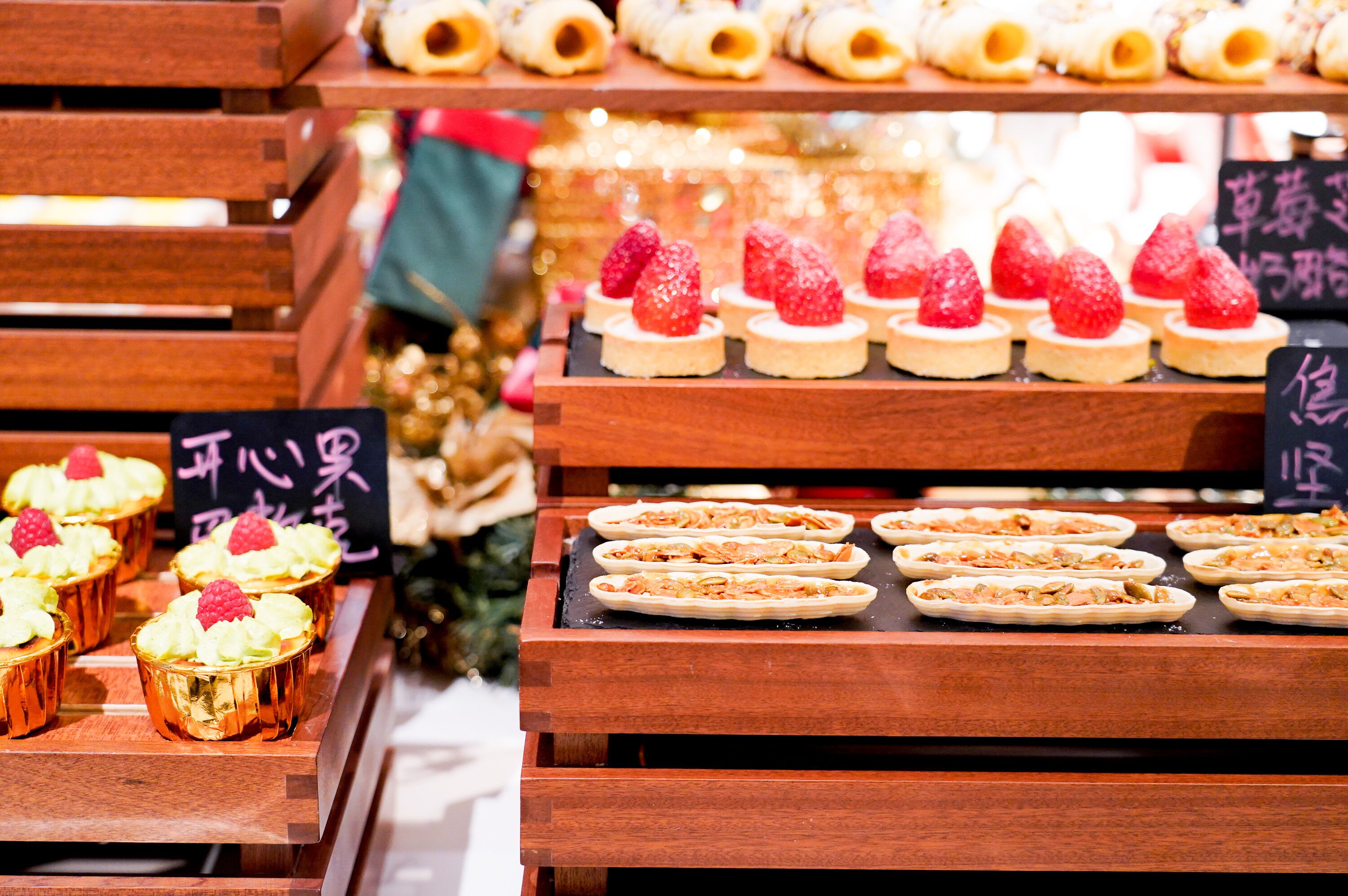 A display of various pastries and desserts on wooden stands.