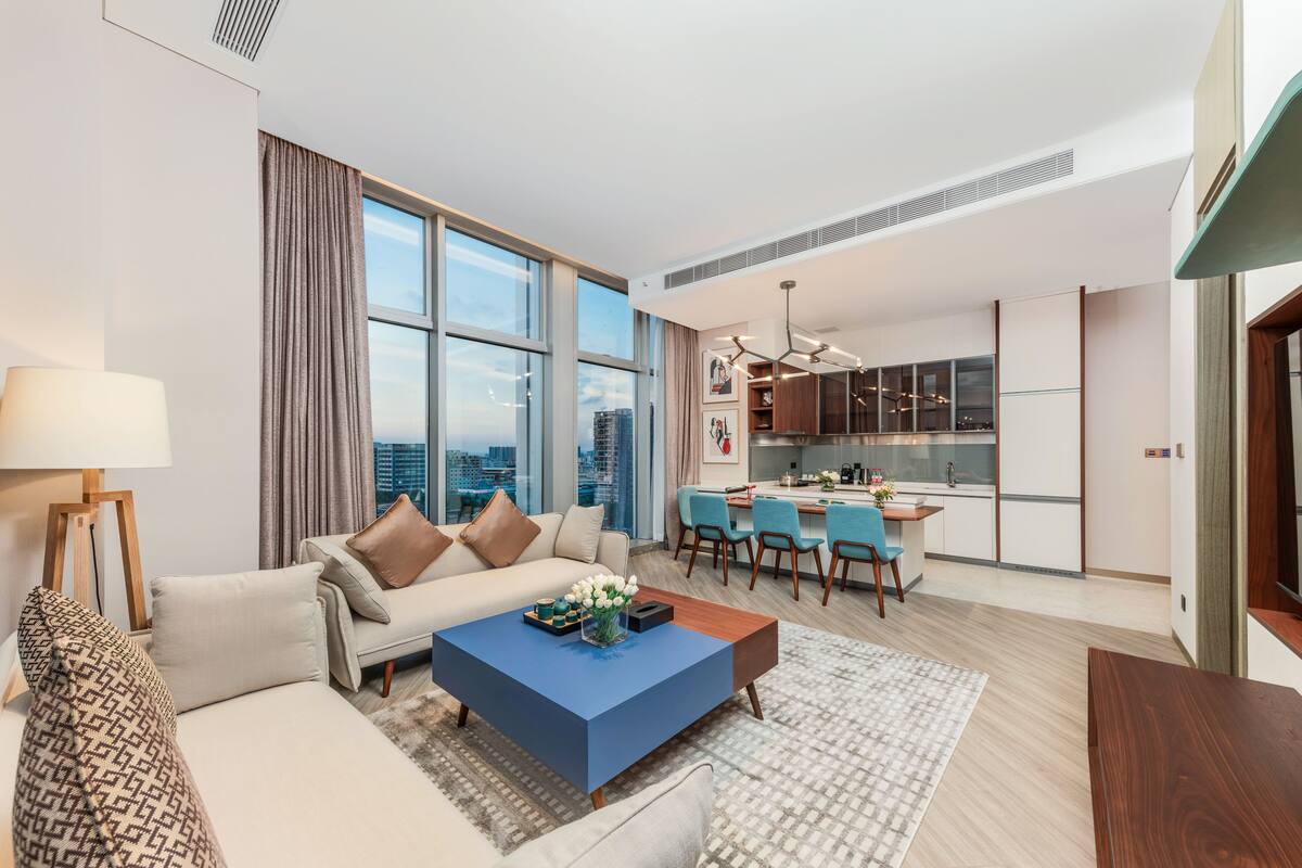 A modern living room with a sofa, coffee table, and dining area.