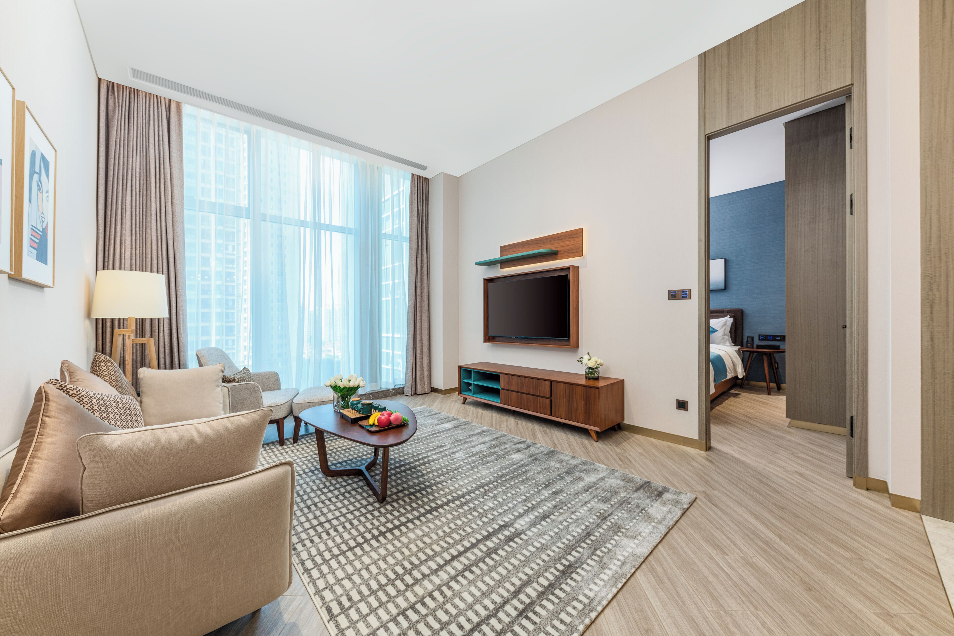Una sala de estar moderna con sofá, mesa de centro y televisor de pantalla plana.