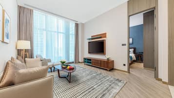 Una sala de estar moderna con sofá, mesa de centro y televisor de pantalla plana.