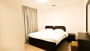 A bedroom with a bed, a nightstand, a dresser, and a mirror. - Central Apartment For Rent 30 (Amman)