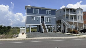 A two-story building with a balcony and a staircase leading to an upper level. - Sun-kissed Mermaid / 846 Ocean Blvd West 2 Bedroom Home by RedAwning (Supply)