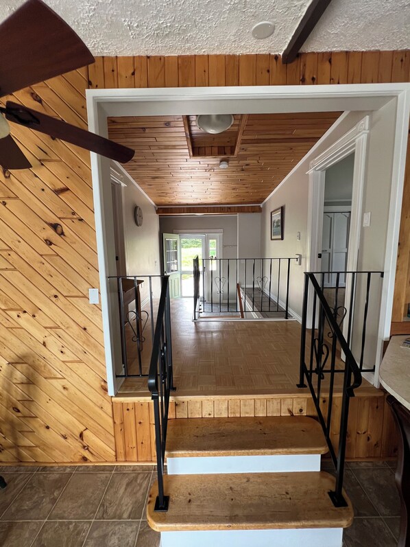 A wooden staircase with black railings leading to a second-floor landing.