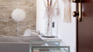 Ein modernes Zimmer mit Backsteinwand, einer weißen Tür und einem kleinen Tisch mit Büchern und einer Vase.