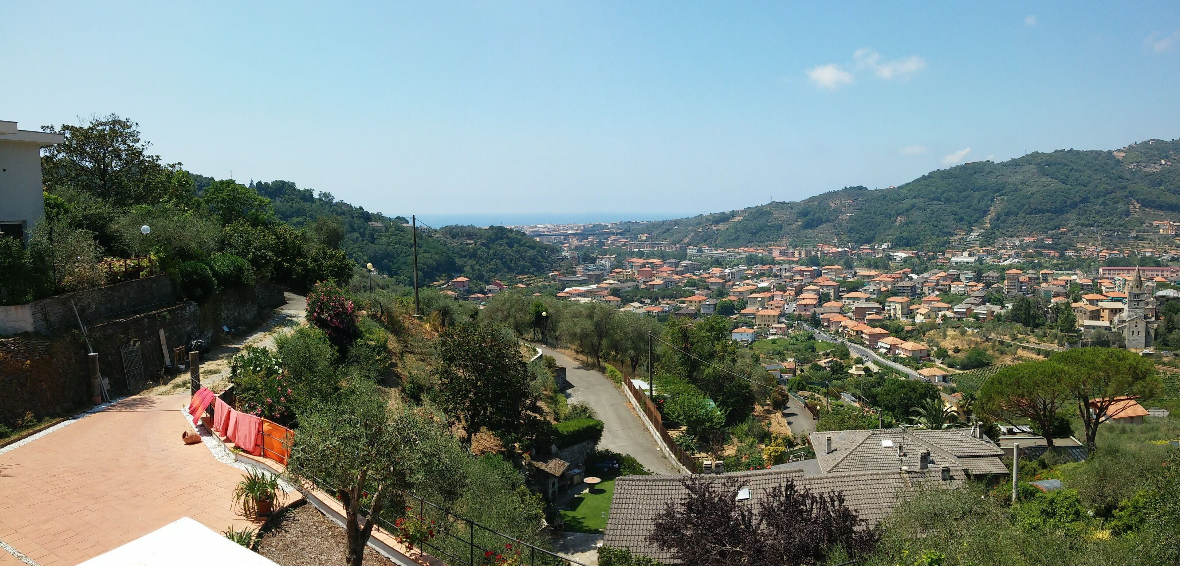 A residential area with a view of a town and hills in the distance.