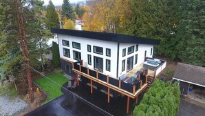 A modern two-story building with a balcony, large windows, and a garage. - WhiskeyJack Estate (Revelstoke)