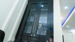 A dark wooden wardrobe with glass doors, a white wall, and a ceiling with recessed lighting. - charming 3-bed apartment in transe ekulu phase 6 (TRANSE EKULU PHASE 6)