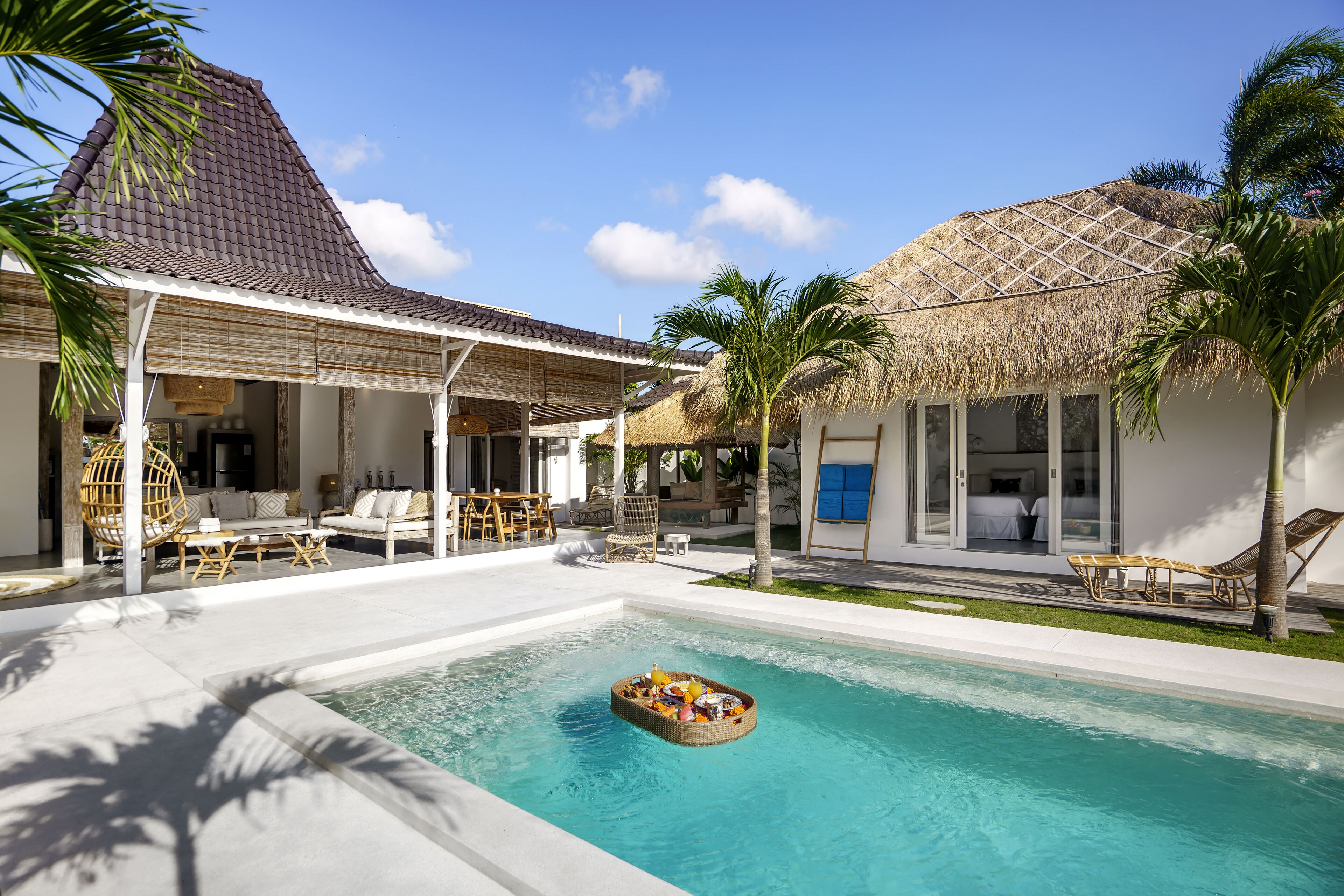 Un espace piscine doté d’un bar flottant, de chaises longues et d’un coin salon abrité.