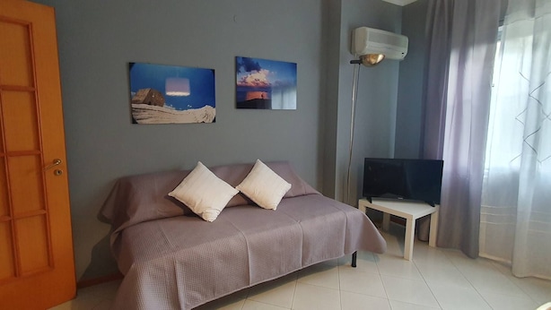 A room with a bed, a TV, and two paintings on the wall. - Relax at the Valley of the Temples (Agrigento)