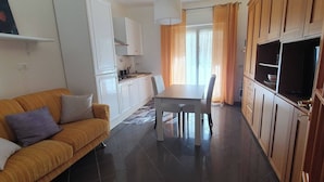 A compact living space with a sofa, a dining table, and a TV. - Relax at the Valley of the Temples (Agrigento)