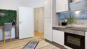 Eine moderne Küche mit Einbauofen, Kaffeemaschine und einer kleinen Bar.