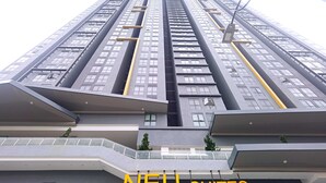 Un edificio de gran altura con varios balcones y un letrero que dice "NEU SUITES".