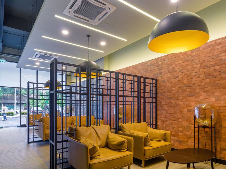 Ein modernes Interieur mit gelben Sofas, einer Ziegelwand und einer großen Pendelleuchte.