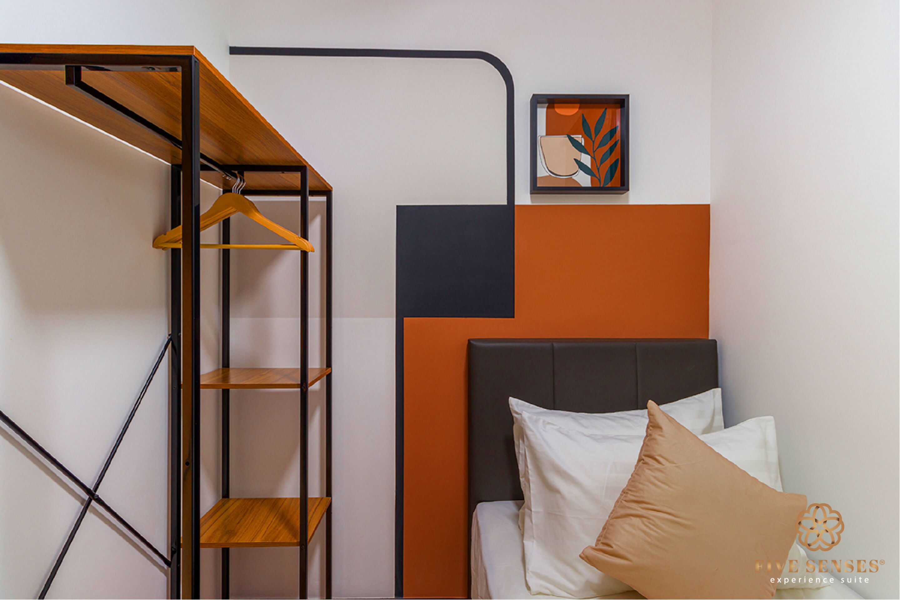 A bedroom with a bed, a wooden shelf unit, and a framed artwork on the wall.
