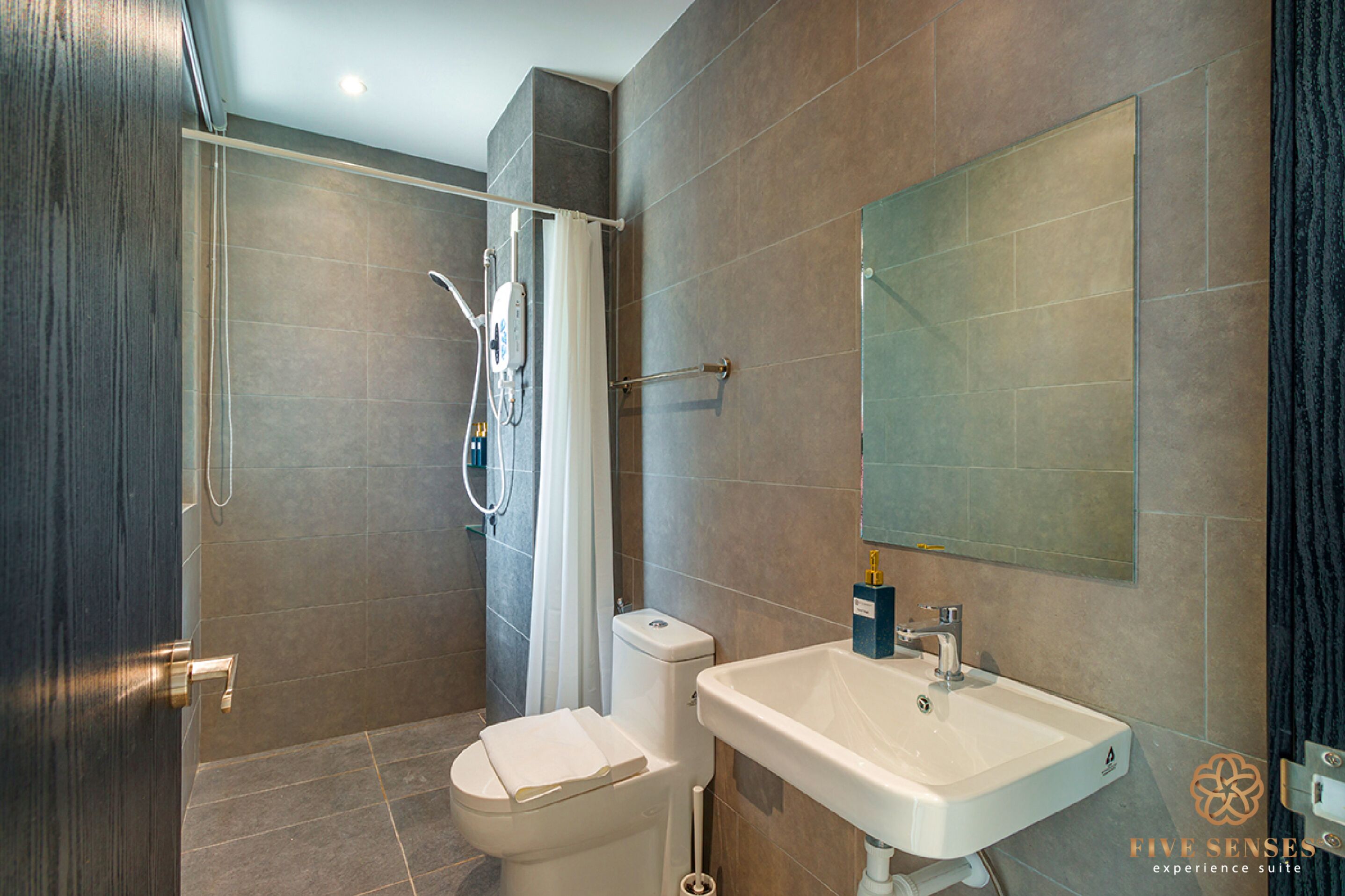 A modern bathroom with a shower, toilet, and sink.
