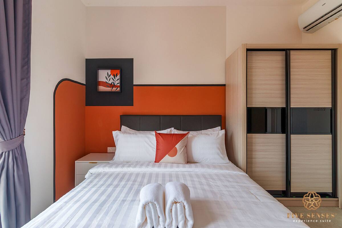 Ein Hotelzimmer mit Bett, Nachttisch, Kleiderschrank und einem gerahmten Bild an der Wand.
