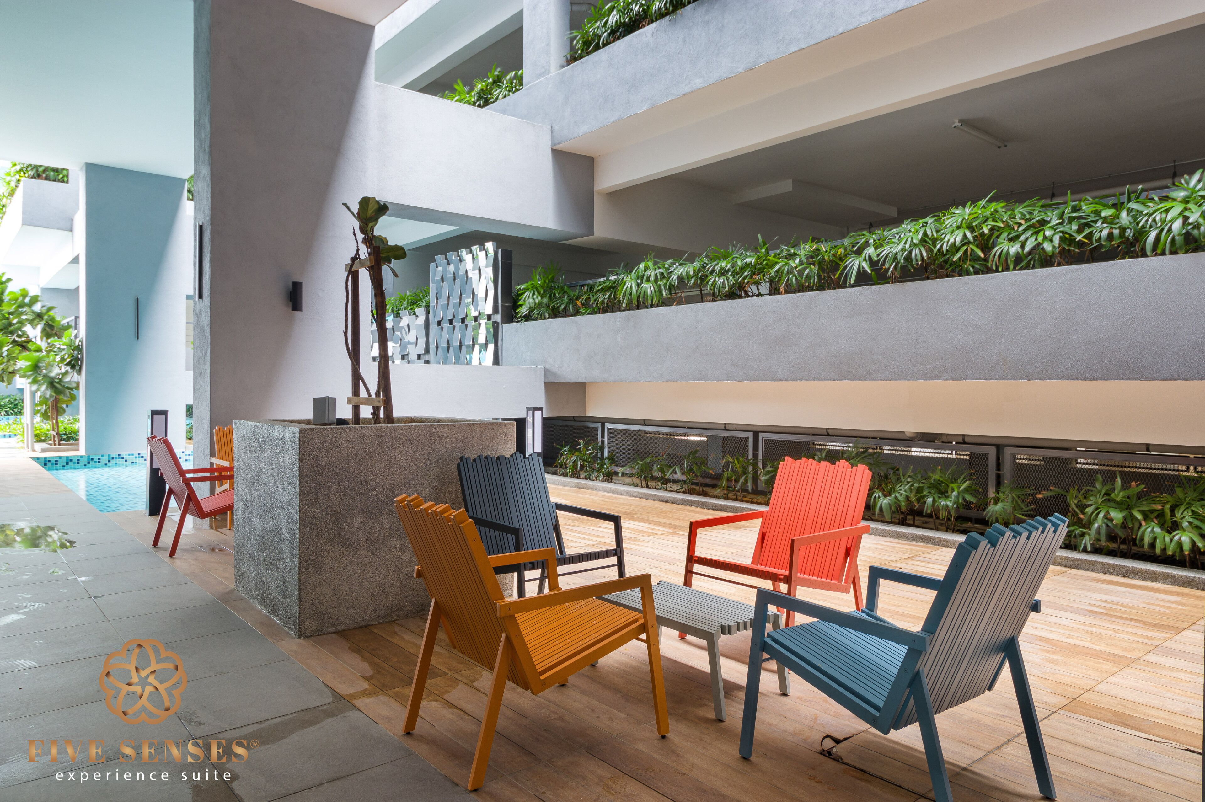 A modern outdoor seating area with a pool, surrounded by greenery and a contemporary design.