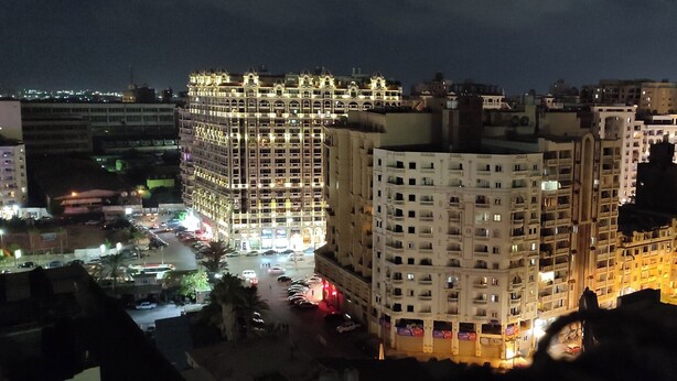 A multi-story hotel with a central courtyard, surrounded by other buildings. - Charming 3-bedroom Apartment in Alexandria With City View (Alexandria)