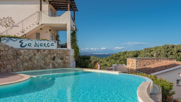 Una piscina con un muro de piedra y un letrero que dice 'Ebianca'.
