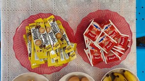 Una mesa con alimentos como pan, huevos, plátanos y paquetes de café.