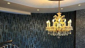 Un intérieur moderne avec un escalier en colimaçon, un lustre et un mur à texture.
