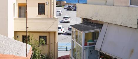 A residential area with buildings, a street, and a view of the sea.