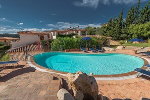 Relax by the serene pool surrounded by lush greenery and mature trees.