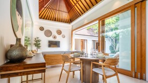 A dining area with a round table and chairs, a large vase, and a painting on the wall. - Top Choice 3 Bedrooms Pool Villa in Central Canggu (Canggu)