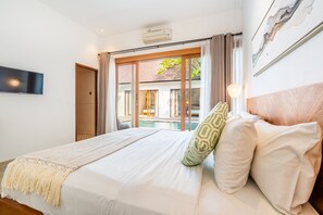 Une chambre d’hôtel avec un lit, une télévision, une fenêtre avec des rideaux et une vue sur la piscine.