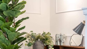 A wooden desk with a plant, a lamp, and a decorative item on a white wall. - Luxury Apartment In The Heart Of Hoylake (Wirral)