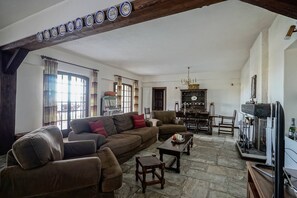 A living room with a large brown sofa, a wooden coffee table, and a fireplace.