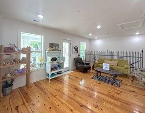A living room with wooden flooring, a sofa, a coffee table, and a bookshelf.