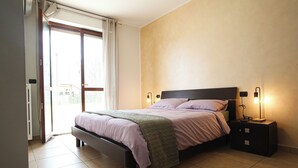A bedroom with a bed, nightstands, and a sliding glass door.