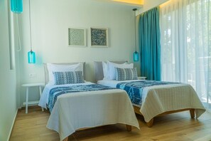 A room with two beds, a small white table, and a window with curtains. - Carpe Diem Villa - Luxurious, 1,5km From The Beach (Rethymno)