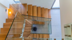 Un escalier moderne avec des rampes en verre et des marches en bois.