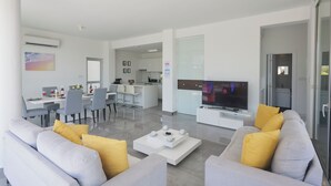 A modern living room with a sofa, coffee table, and TV.