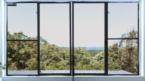A large window with a view of dense greenery and a distant landscape. - Victoria St. Beach House, Coffs Jetty
5 Bedroom PET Friendly Airconditioned (Coffs Harbour)