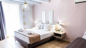 Una habitación de hotel con cama, mesitas de noche, lámpara y cuadros en la pared.
