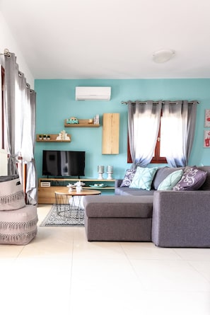 Ein Wohnzimmer mit einer Couch, Fernseher und Dekoration.