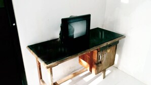Un bureau en bois avec un téléviseur posé dessus.