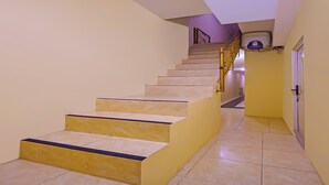 Eine Treppe mit Handlauf und einer Tür am Fuß.