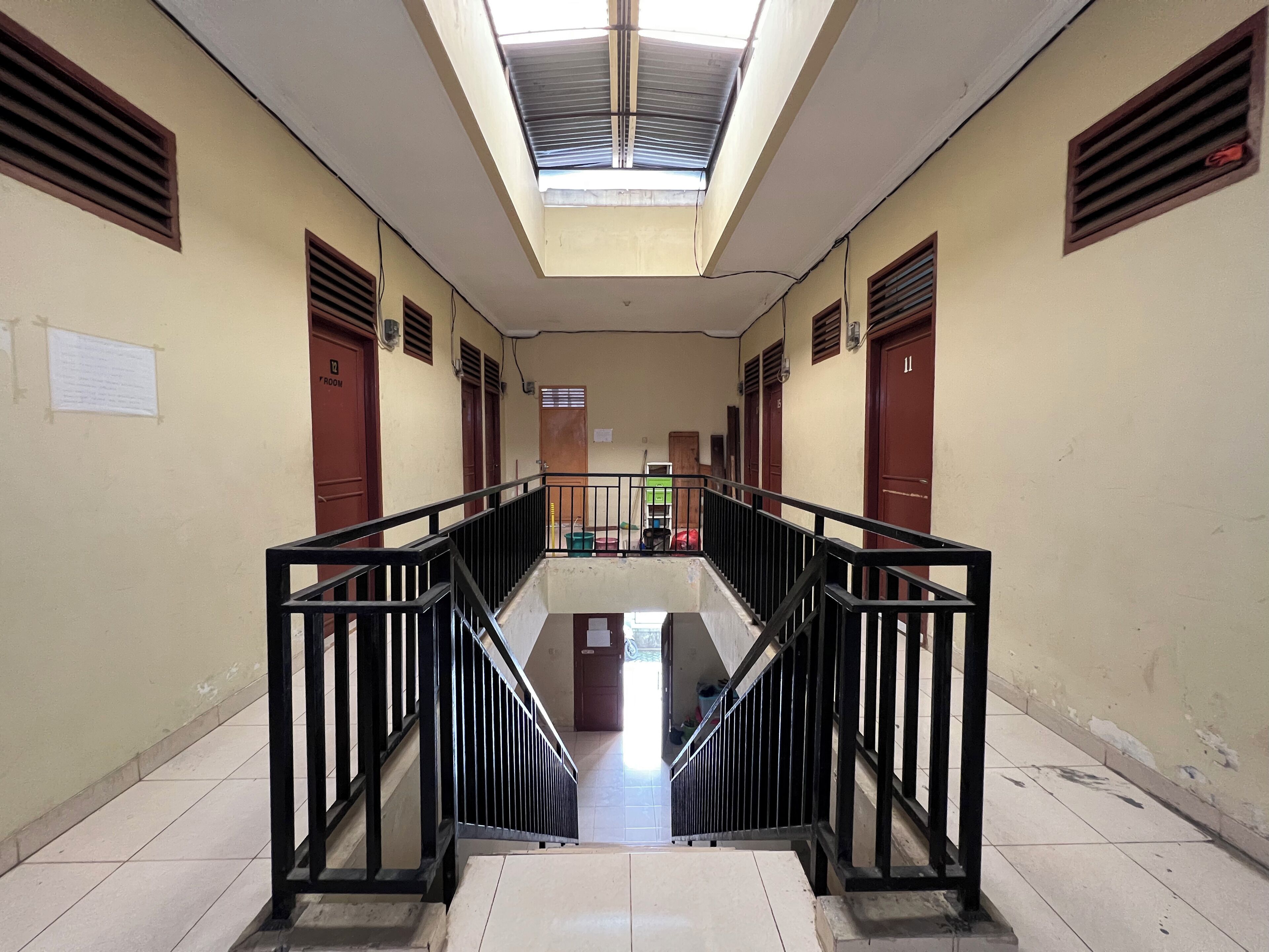 A corridor with a central staircase, flanked by doors labeled "ROOM" and "ROOM".