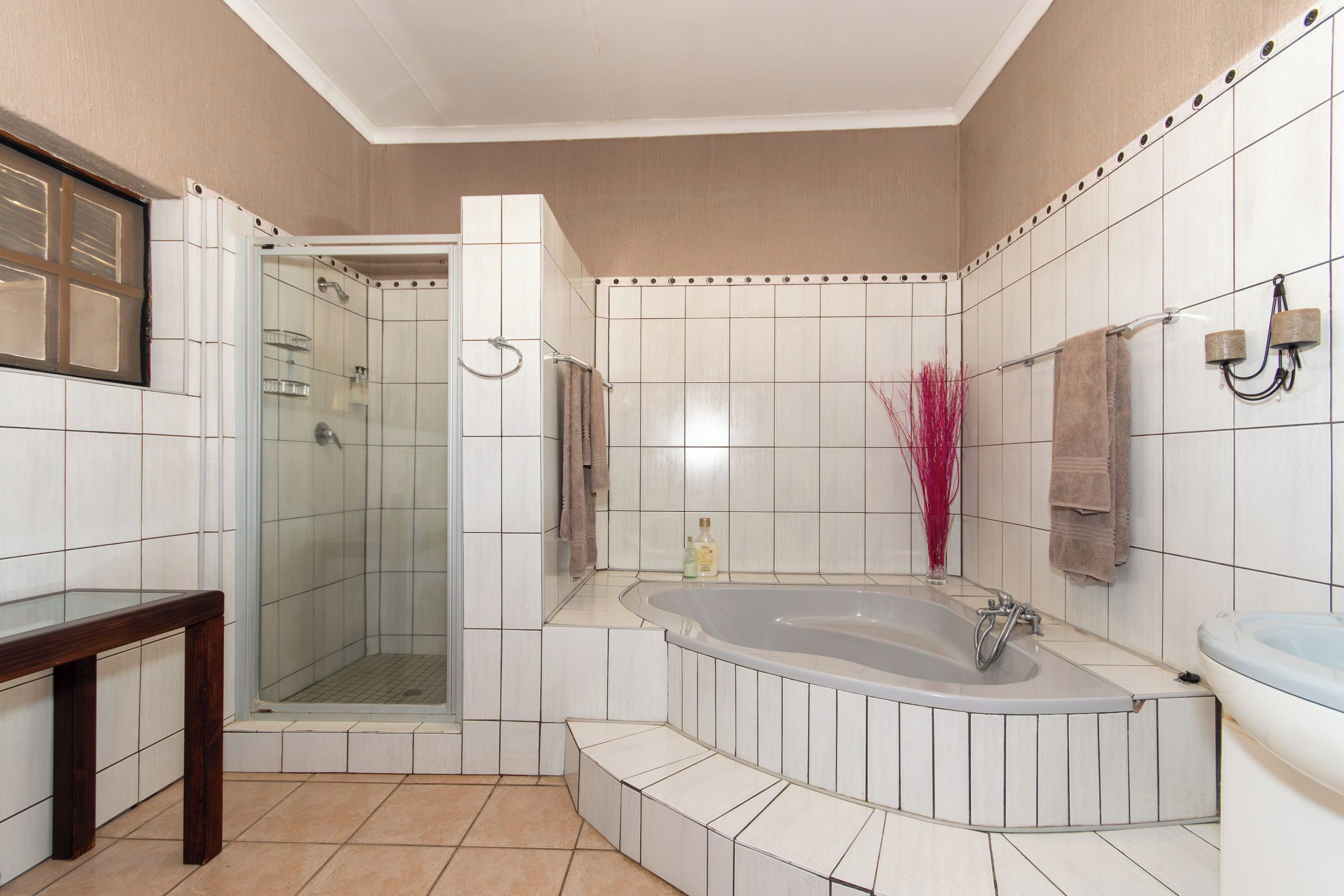 Une salle de bain dotée d’une douche à parois de verre, d’une baignoire sur pieds et d’un meuble-lavabo avec miroir.