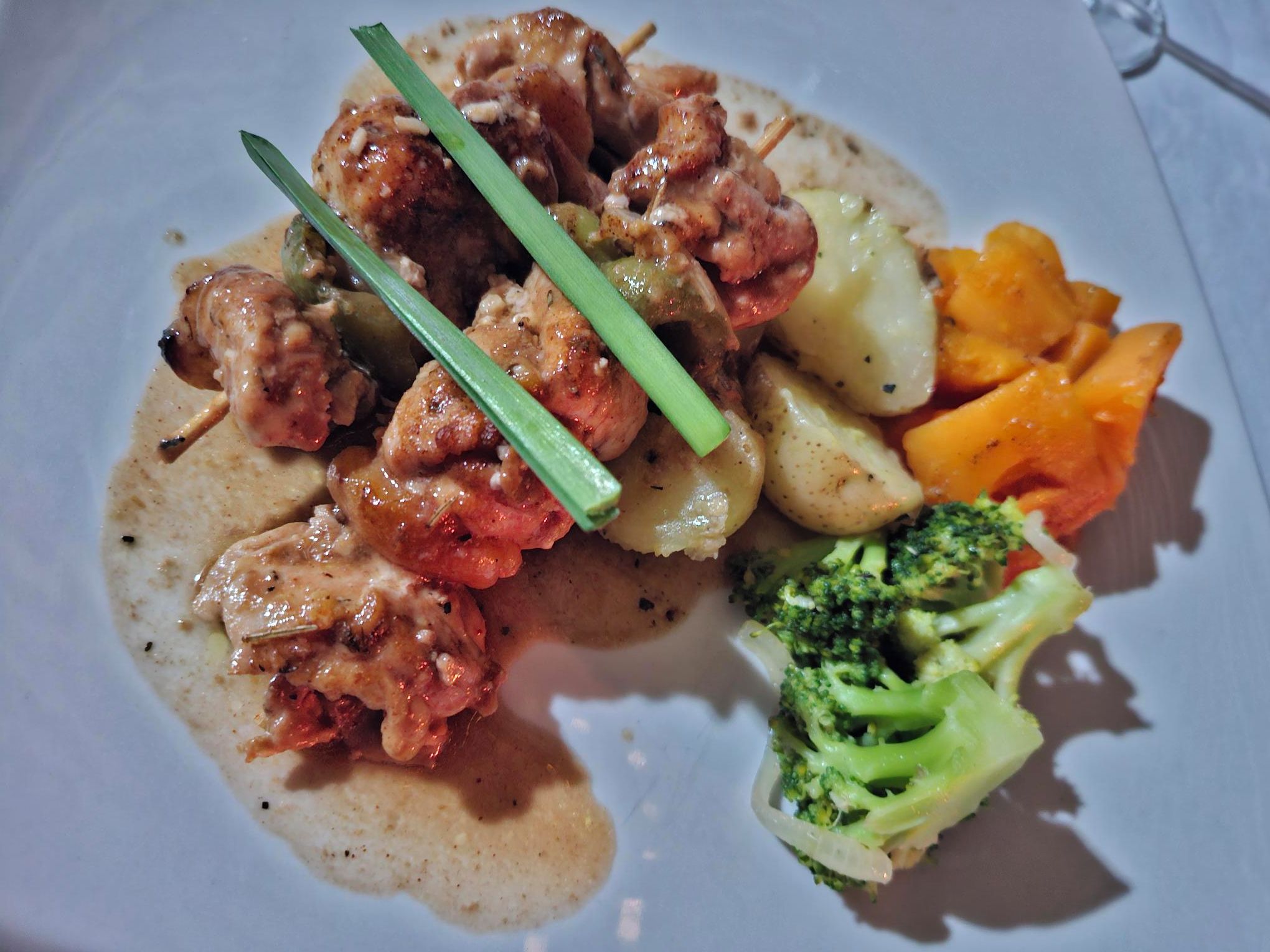 Un plato con pollo, papas y brócoli.
