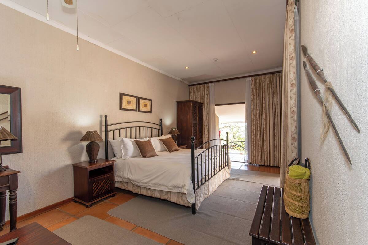 A bedroom with a bed, bedside tables, a wardrobe, and a bench.
