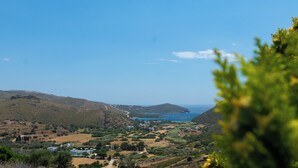 Eine Küstenlandschaft mit blauem Himmel, einer kleinen Siedlung und weiter Wasseransicht.