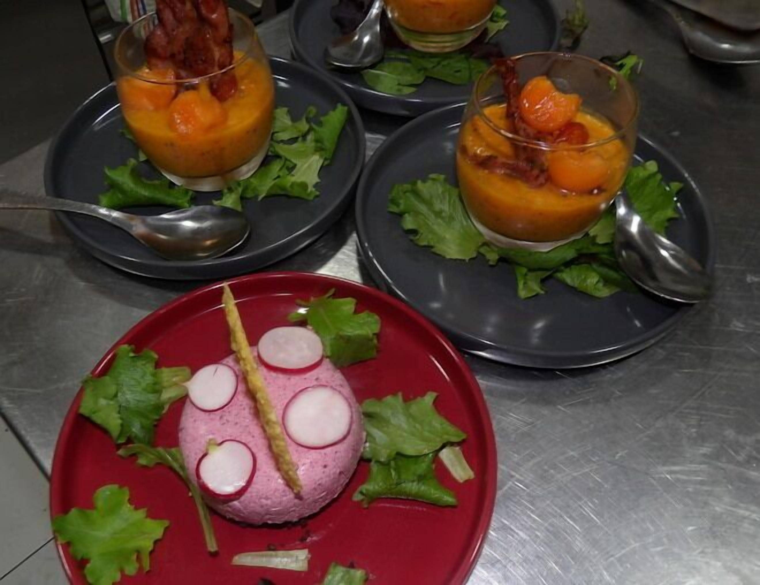 A table with three plates of food, each with a different dish and garnished with lettuce.
